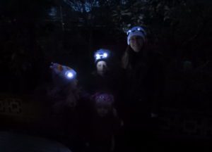 Family wearing Bright Eyes hats with eyes lit up