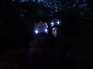 Children wearing Bright Eyes hats with eyes lit up