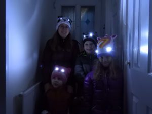 Family wearing Bright Eyes hats with eyes lit up