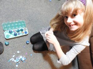 Smiling girl opening toy egg