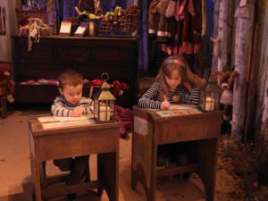 Children writing letters to Father Chistmas at desks in LaplandUK