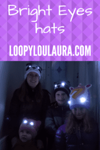 Pinnable pic of Family wearing Bright Eyes hats with eyes lit up