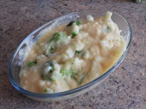 vegan cheese sauce poured over cauliflower and broccoli