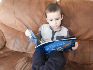 Child reading What Makes A Lemur Listen?